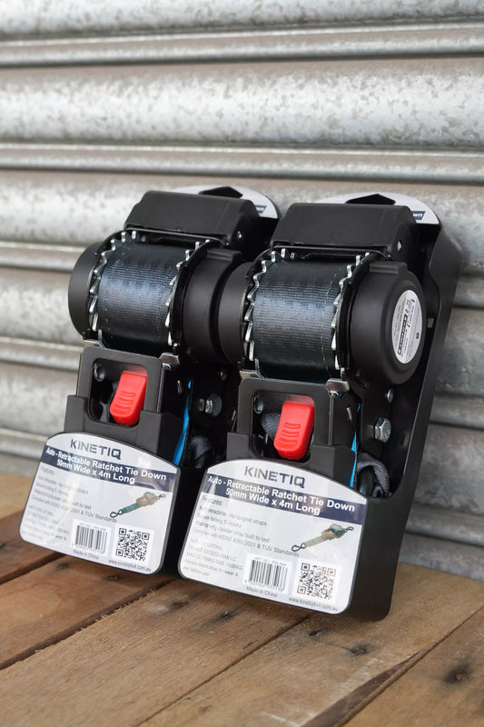 Set of 2 KINETIQ automatic retractable ratchet straps, each 4m long and 50mm wide, with black and orange components.