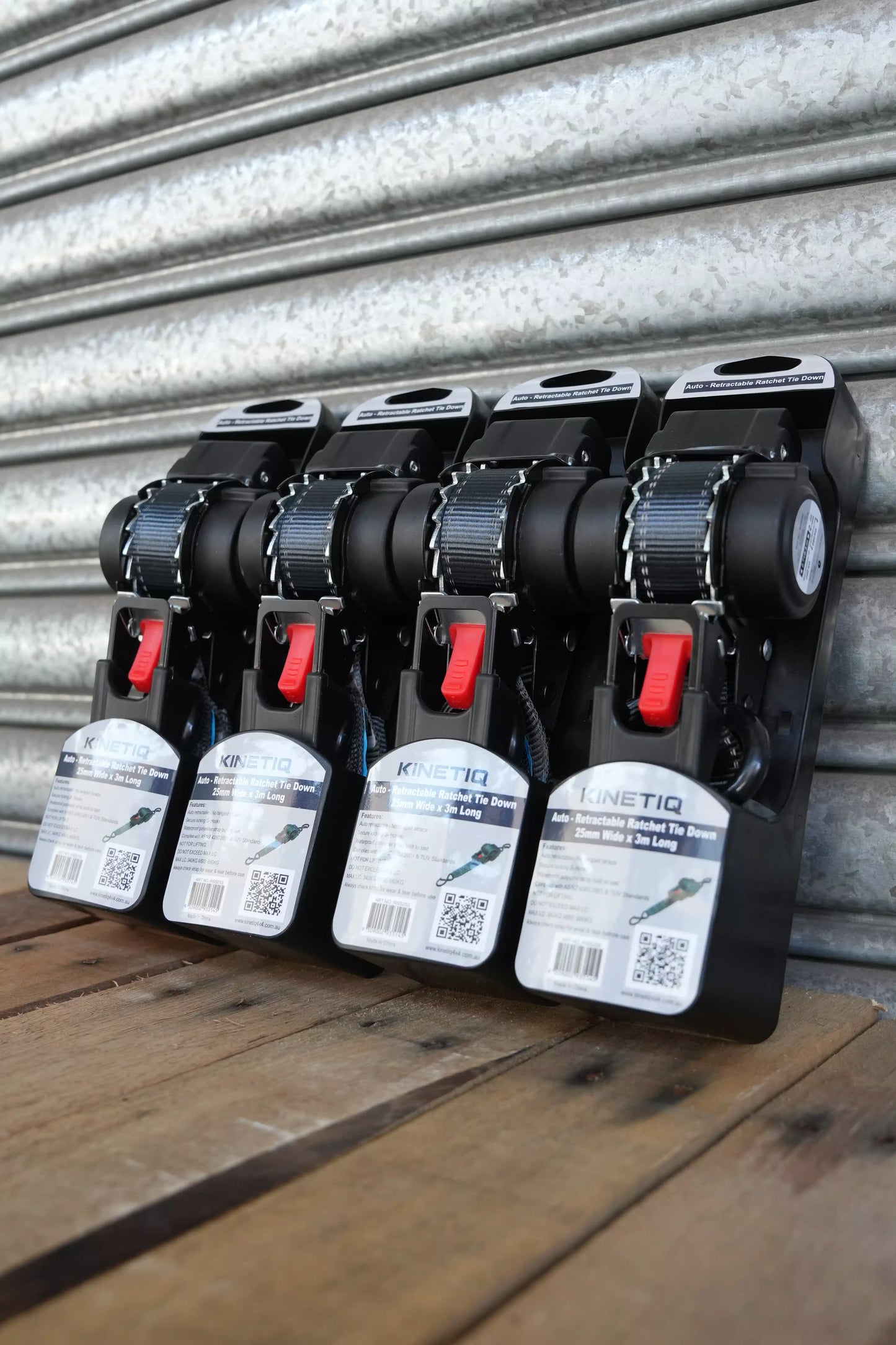 Set of 4 KINETIQ automatic retractable ratchet straps, each 3m long and 25mm wide, with black and orange ratchet mechanisms.