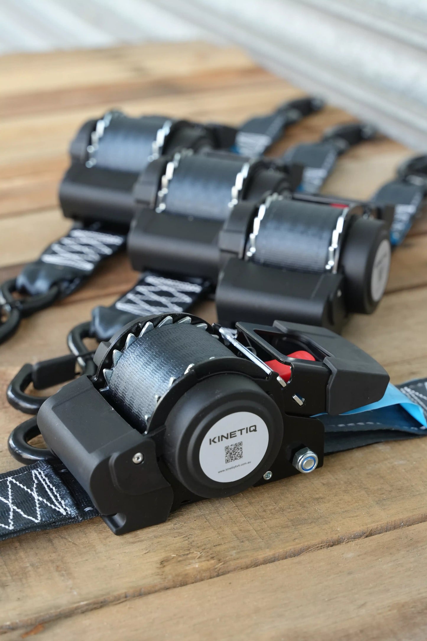 Set of 4 KINETIQ automatic retractable ratchet straps, each 4m long and 50mm wide, with black and orange components.