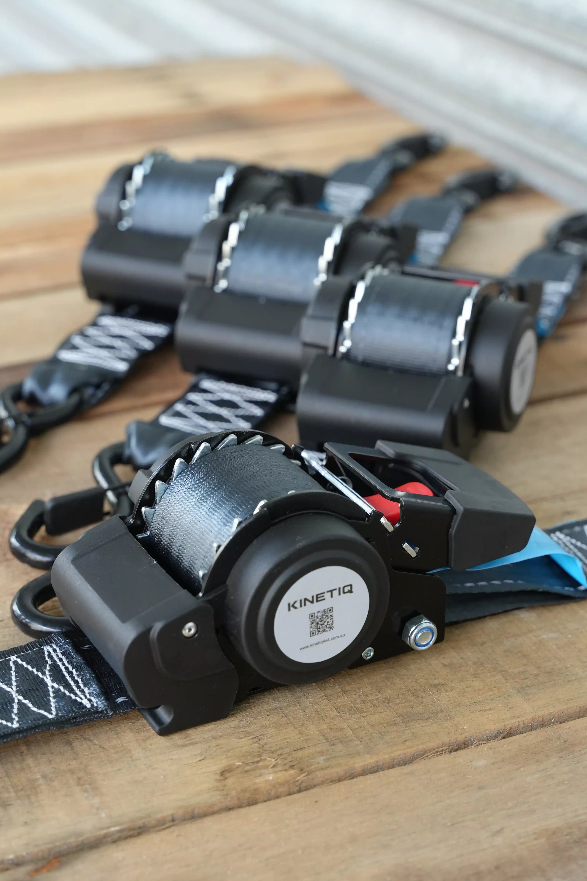 Set of 4 KINETIQ automatic retractable ratchet straps, each 4m long and 50mm wide, with black and orange components.